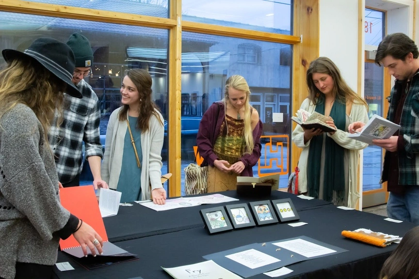 Attendees looks through student crafted books
