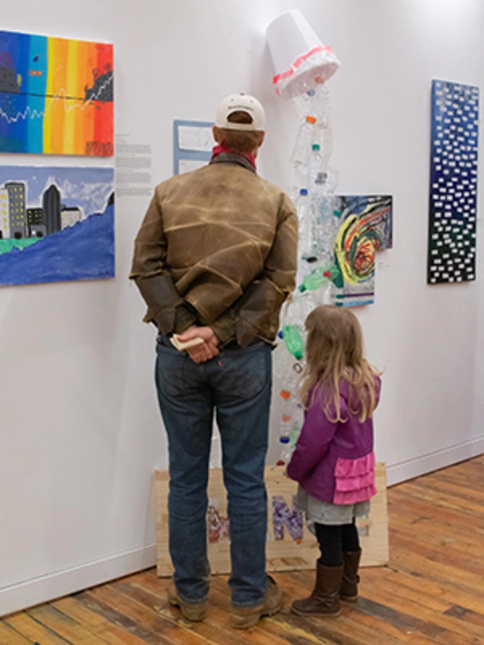 Community members look at showcase art